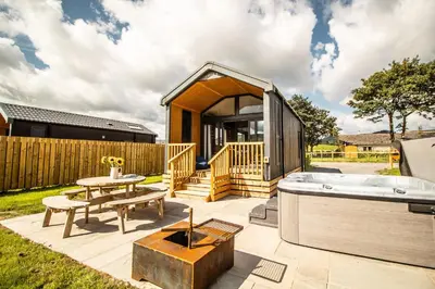 a tiny house with a hot tub on a patio at Daverneithon 2 in Rhayader