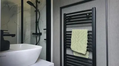a bathroom with a white sink and a towel rack at Daverneithon 2 in Rhayader