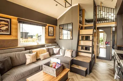 a living room with a couch and a loft bed at Daverneithon 1 in Rhayader