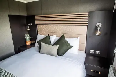 a bedroom with a white bed with green pillows at Daverneithon 1 in Rhayader