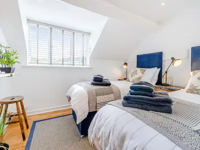 two beds in a room with white walls and a window at Pen Y Groes in Welshpool