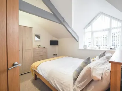 a bedroom with a large bed and a window at Sailhouse Loft New Quay in New Quay