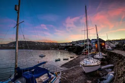 a group of boats docked in a harbor at sunset at Sailhouse Loft New Quay in New Quay