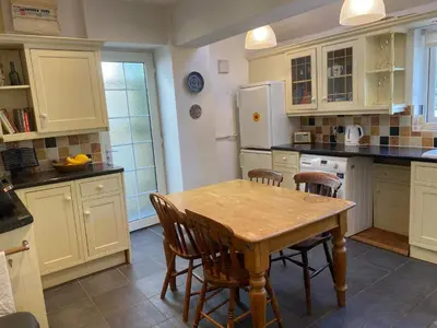 a kitchen with a wooden table and some chairs at Brecon with Spectacular Views in Brecon