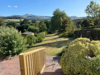 a garden with a wooden fence and bushes at Brecon with Spectacular Views in Brecon