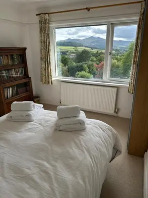 a bedroom with a white bed with a large window at Brecon with Spectacular Views in Brecon