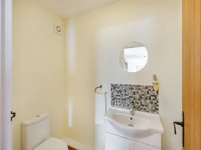 a bathroom with a white toilet and a sink at Orchard Barn in Llandrindod Wells