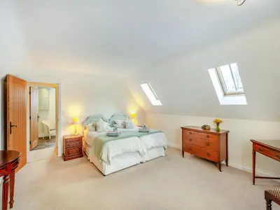 a white bedroom with a bed and a mirror at Orchard Barn in Llandrindod Wells
