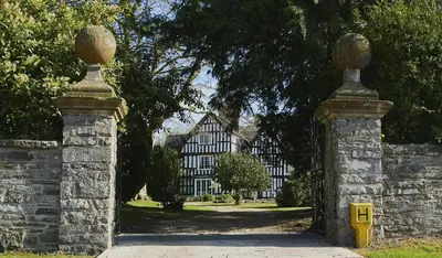 an entrance to a building with two stone pillars at Rorrington Hall in Chirbury