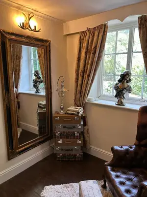 a living room with a mirror and a couch at Rorrington Hall in Chirbury