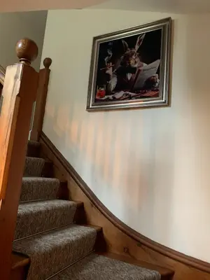 a picture hanging on a wall next to a staircase at Rorrington Hall in Chirbury