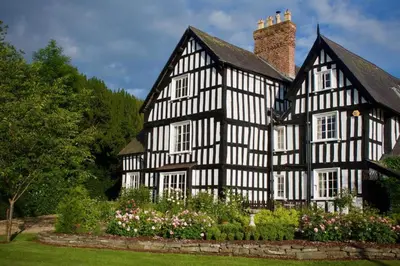 an old black and white house with a garden at Rorrington Hall in Chirbury