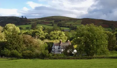 a house in the middle of a green field at Rorrington Hall in Chirbury