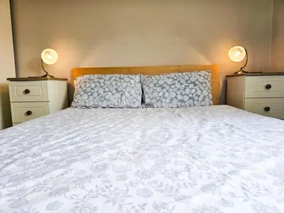 a bedroom with a large bed with two night stands at Five Oaks B&B - New Quay in Llanina