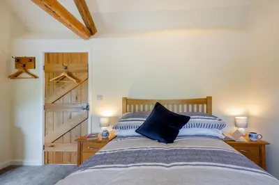 a bedroom with a bed and a wooden door at 3 Bed in Tywyn oc-b32570 in Llangelynin