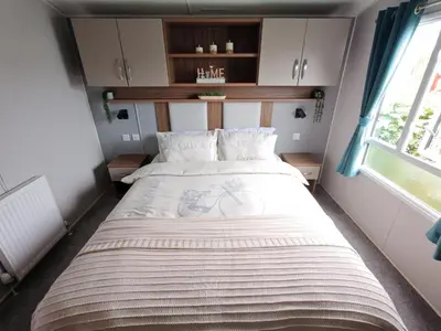 a large bed in a small room with a window at The Ocean Nook in New Quay