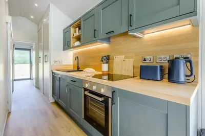 a kitchen with blue cabinets and a wooden counter top at 2 Bed in Cemmaes oc-a32660 in Cemmaes