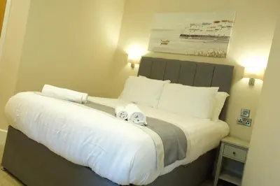 a bedroom with a large bed with two towels on it at The Barmouth Bar & Grill in Barmouth