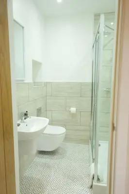 a bathroom with a toilet and a sink and a shower at The Barmouth Bar & Grill in Barmouth