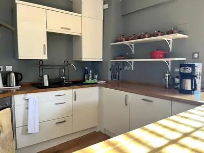 a kitchen with white cabinets and wooden counter tops at Rooftops in Hay-on-Wye
