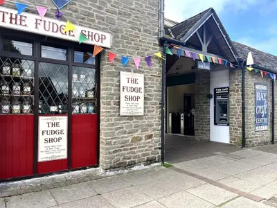 a brick building with red doors and signs on it at Rooftops in Hay-on-Wye
