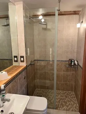 a bathroom with a shower with a toilet and a sink at Rooftops in Hay-on-Wye