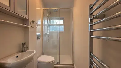 a bathroom with a shower and a toilet and a sink at Barmouth Beach Ground Floor Studio in Barmouth