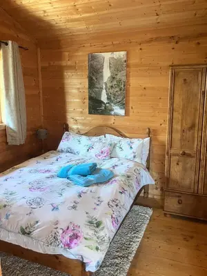 a bedroom with a bed in a log cabin at Perfect getaway Cabin Haf with Hot Tub in Llanrhaeadr-ym-Mochnant