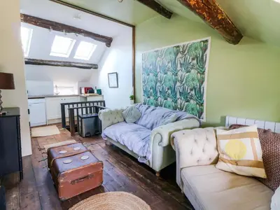 a living room with a couch and a table at The Little Laura Ashley House in Machynlleth