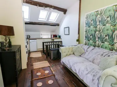 a living room with a couch and a kitchen at The Little Laura Ashley House in Machynlleth