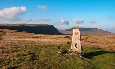 a stone pillar in a field with mountains in the background at Vern Dale Cottage, Erwood, River Wye, Builth Wells in Builth Wells
