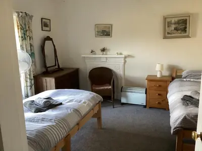 a bedroom with two beds and a fireplace at Large farmhouse in Snowdonia, North Wales in Talsarnau