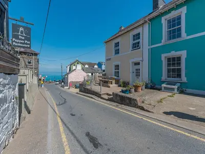 an empty street next to a blue and white building at Spring Gardens in New Quay