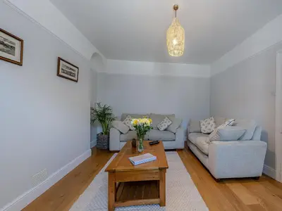 a living room with a couch and a table at Spring Gardens in New Quay