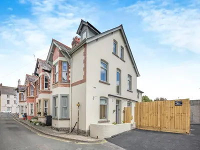 a white house with a wooden fence on a street at Lansdowne House in Brecon