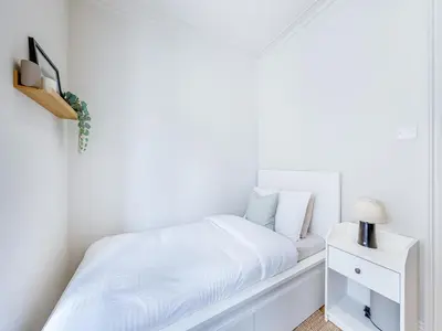 a white bedroom with a bed and a nightstand at Lansdowne House in Brecon