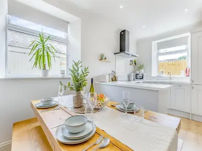 a kitchen with a wooden table with plates and glasses at Lansdowne House in Brecon