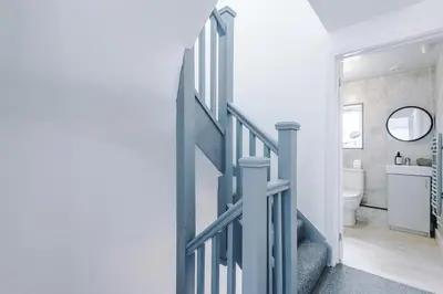 a hallway with a blue door leading to a bathroom at Double the Comfort - 2 Hansas Luxury & Spacious Townhouses by Parydise Properties - Ideal for Business or Family in Harlescott