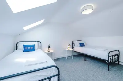 two beds in a room with two tables at Double the Comfort - 2 Hansas Luxury & Spacious Townhouses by Parydise Properties - Ideal for Business or Family in Harlescott