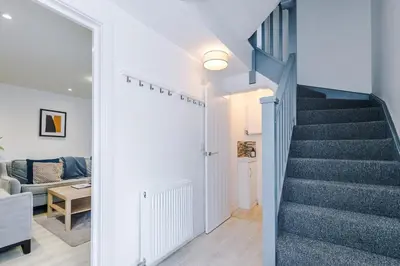 a stairway leading to a living room with a blue staircase at Double the Comfort - 2 Hansas Luxury & Spacious Townhouses by Parydise Properties - Ideal for Business or Family in Harlescott