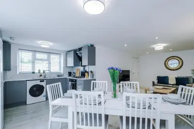 a kitchen and living room with a white table and chairs at Double the Comfort - 2 Hansas Luxury & Spacious Townhouses by Parydise Properties - Ideal for Business or Family in Harlescott