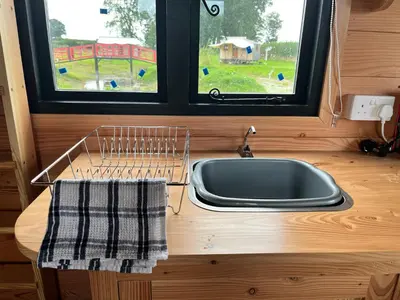 a kitchen counter with a sink and a window at Black Bridge Cabin in Lyonshall