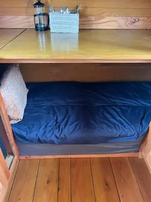 a shelf with a blue pillow under a table at Black Bridge Cabin in Lyonshall