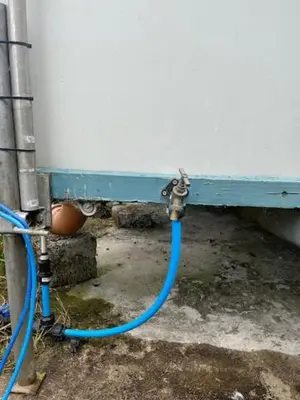 a blue hose is hooked up to a wall at Tick Bridge cabin in Lyonshall