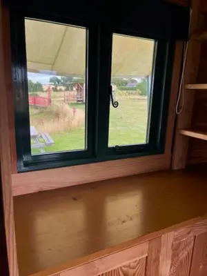a window in a room with a view of a field at Tick Bridge cabin in Lyonshall
