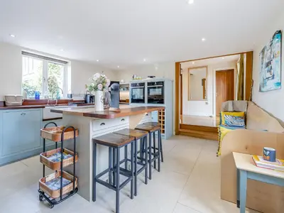 a kitchen with a counter and some bar stools at Hays Boathouse-Maes-Y-Caer in Hay-on-Wye