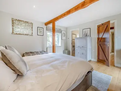 a bedroom with a large white bed in a room at Hays Boathouse-Maes-Y-Caer in Hay-on-Wye