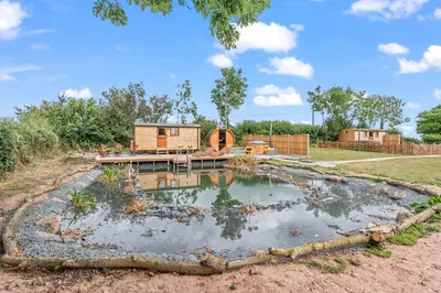 a holiday house with a pond in the yard at Starry Nights Escape - Hot Tub & Sauna in Yarpole