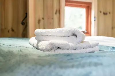 a stack of towels sitting on top of a bed at Starry Nights Escape - Hot Tub & Sauna in Yarpole