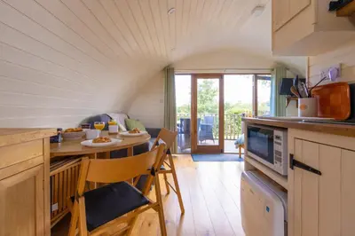 a kitchen with a table and a dining room at Pod2 - Powys River Pods - Pet Friendly Glamping Pod Builth Wells Powys Wales in Garth